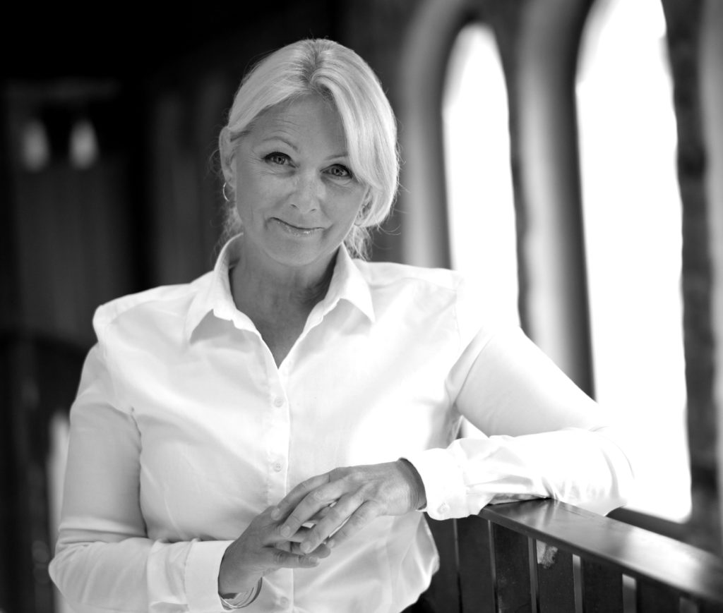 Portrettbilde av Siri Nodland, generalsekretær i Fundraising Norge. Hun har på seg hvit skjorte og står foran et vindu. Bildet er i sort/hvitt.