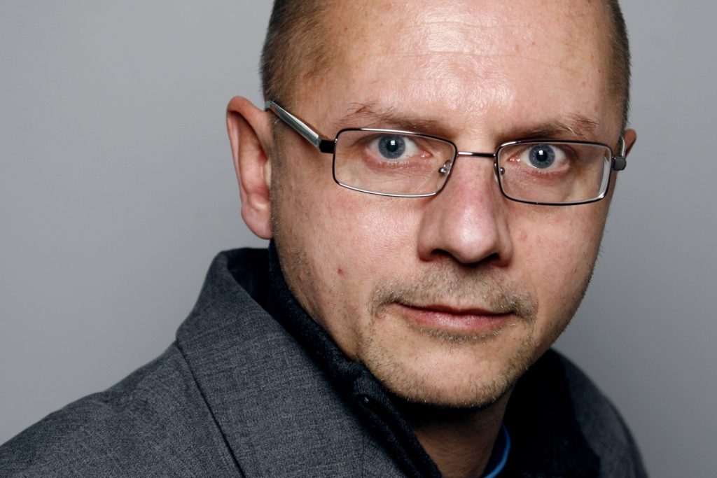 Portrettbilde av professor Runar Døving. Han har på seg briller, en grå blazer og mørk skjorte.