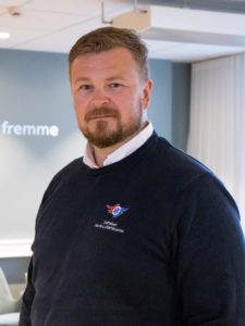 Portrettbilde av Karl Magnus Rohde-Næss, Markedssjef i Stiftelsen Norsk Luftambulanse. Har har på seg en mørkeblå genser med Luftambulansen sin logo.