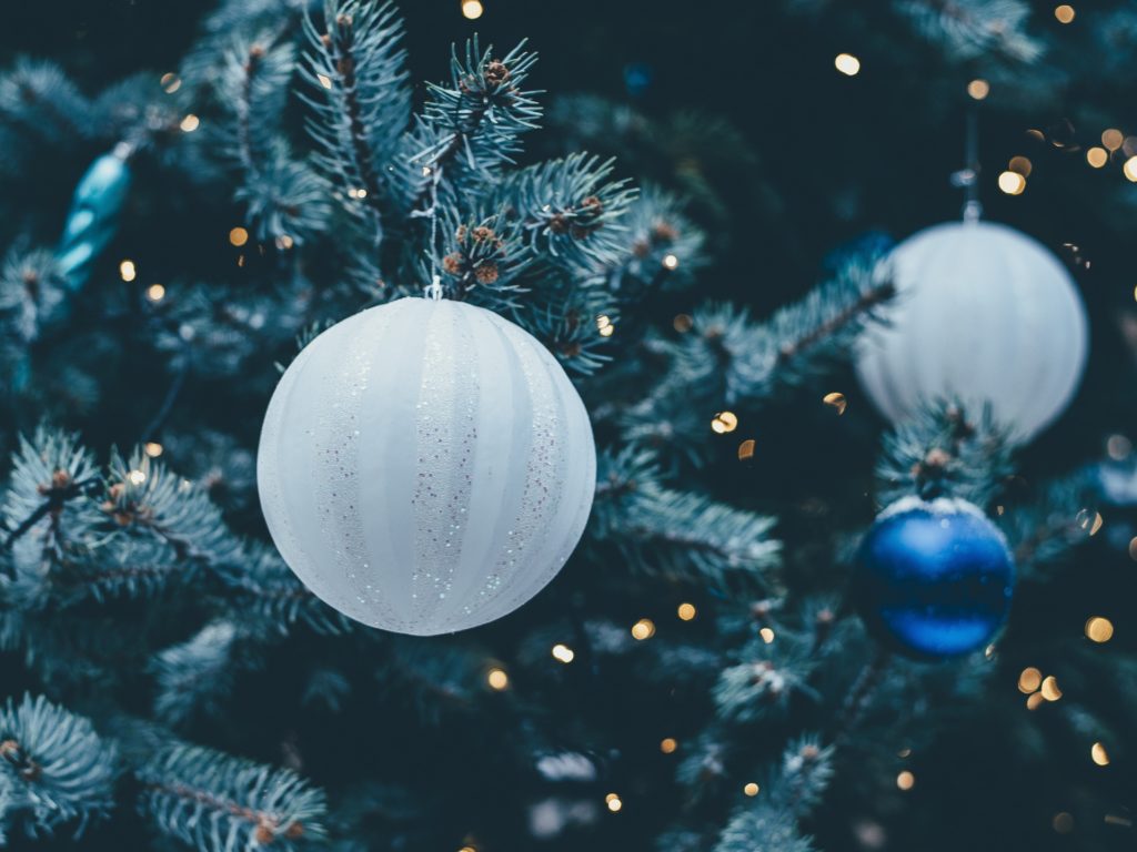 Hvite og blå julekuler på et tre. 
